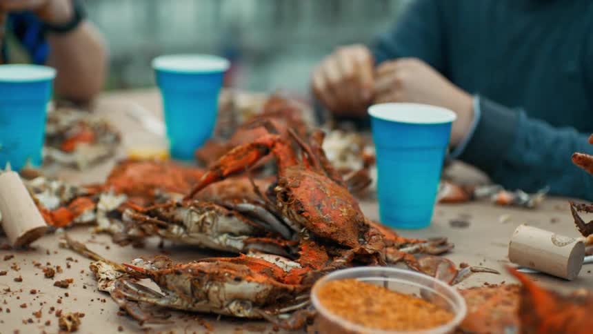 Two people sitting at a table eating large crabs
