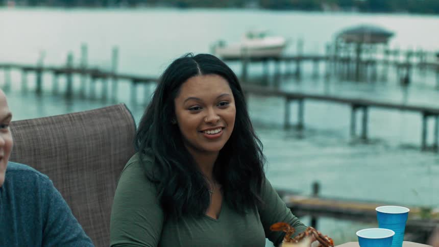 Four people sit outdoors with drinks and seafood