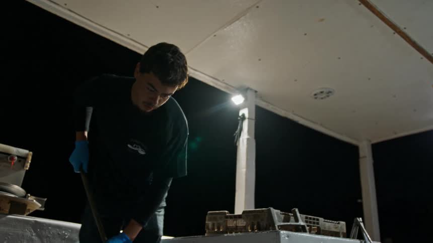 Man inside a boat at night cleaning