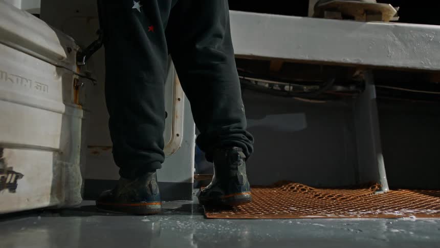 Legs of a man inside a fishing boat
