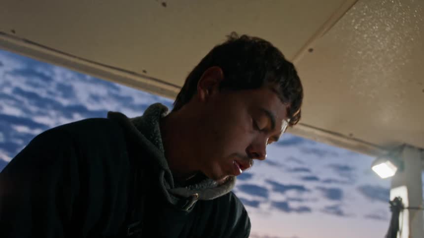 Portrait of a man inside a boat overlooking the purple dawn sky