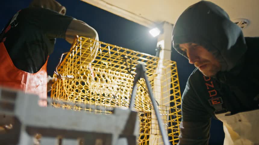 Two commercial fishermen working on a boat