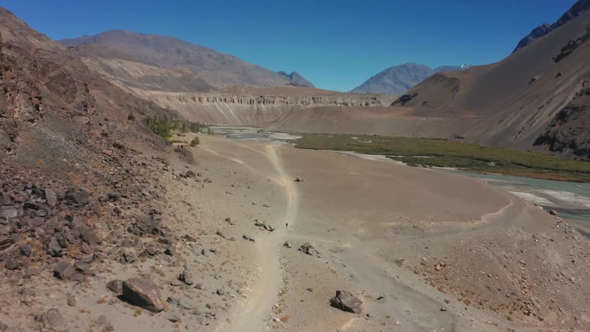 A road next to a river in a mountain valley