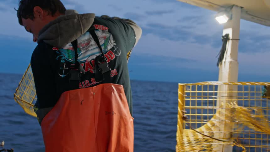 Man throwing a crab fishing cage into the sea