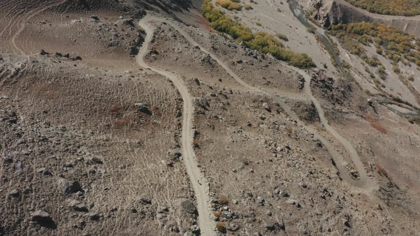 Aerial footage of dirt trail a person can be seen walking