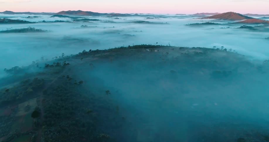 Aerial view of mountains and plains covered in fog