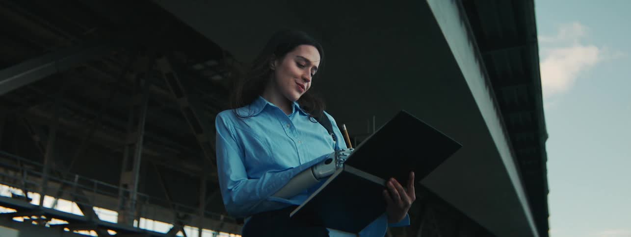 Woman with a prosthetic arm sketches a picture on a tablet
