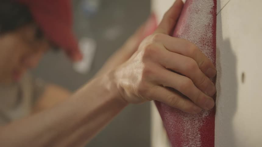 Closeup of a mans hand climbing a wall of climber training