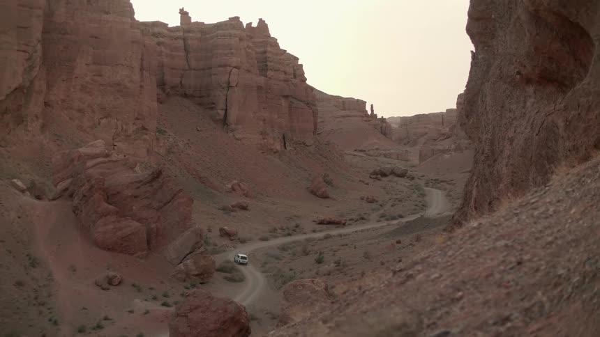 A car driving on a road across a canyon