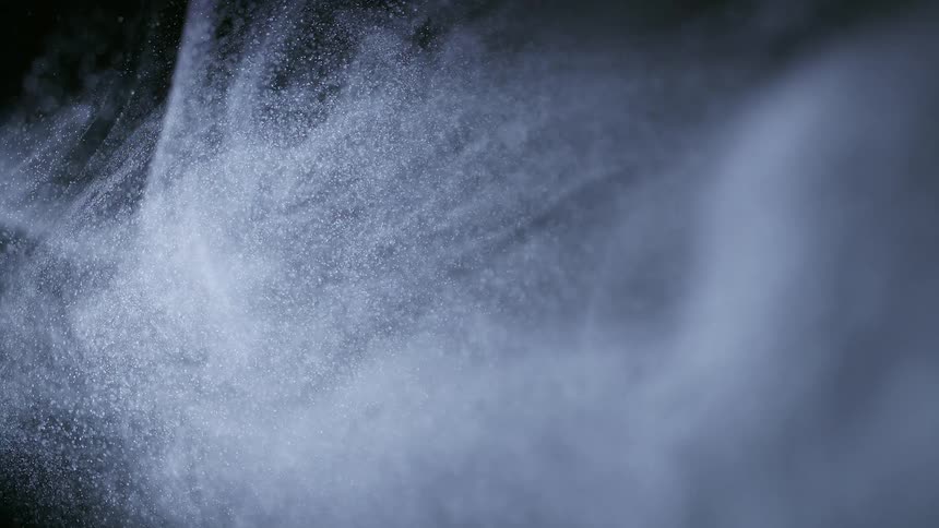 Extreme closeup on a white powder on a black background in abstract movements and slow motion