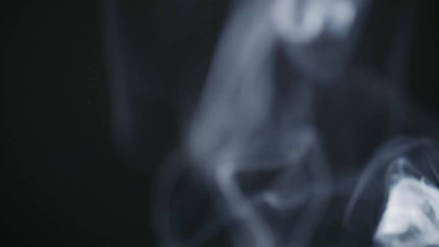 Close up of white smoke rising against a black background