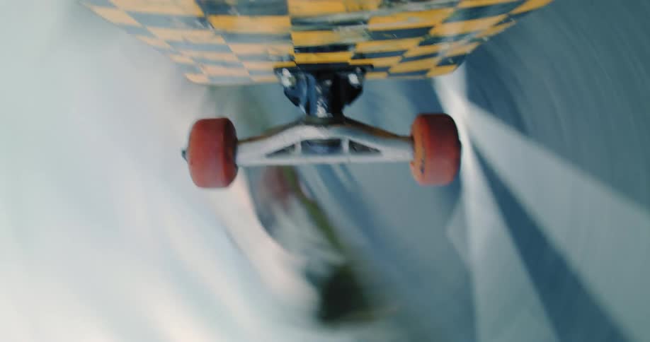 A skateboard is seen from underneath as a trick is performed