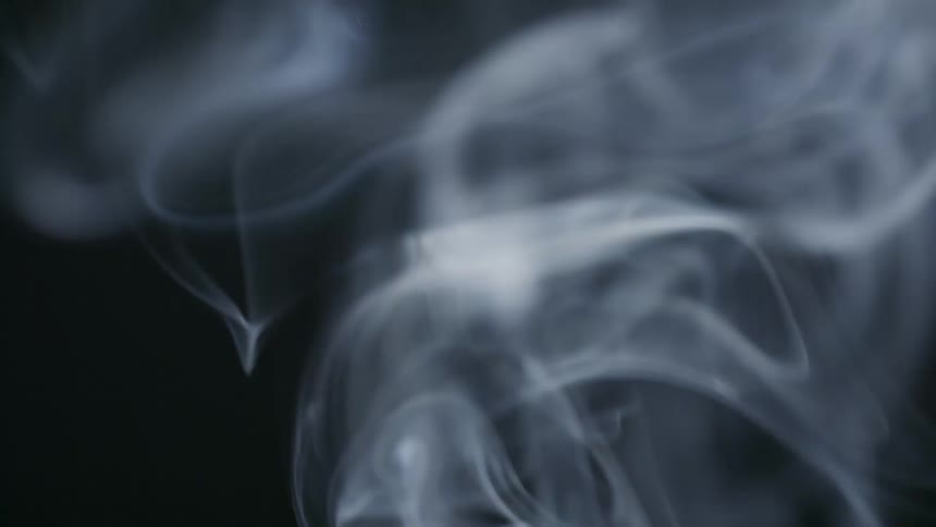 Close up of white smoke rising against a black background