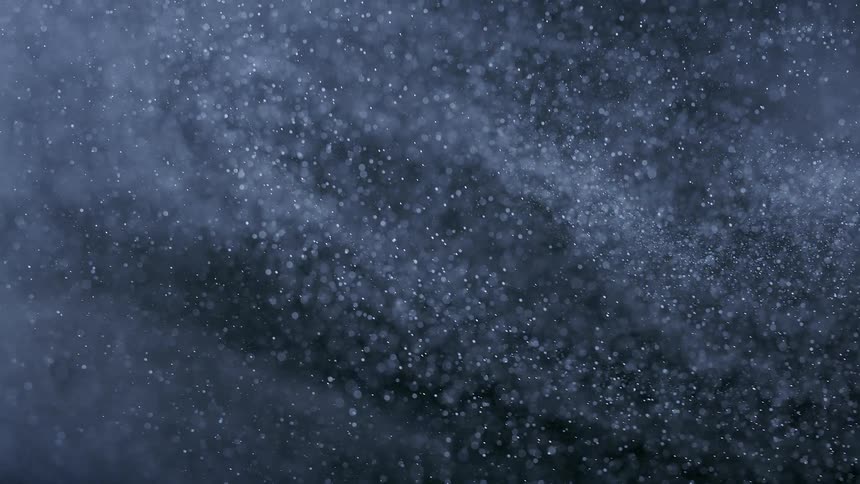 Extreme closeup on an abstract moving white powder and a black background