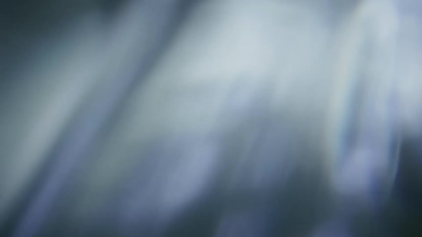 Extreme closeup on an object with an abstract beam of light on a black background