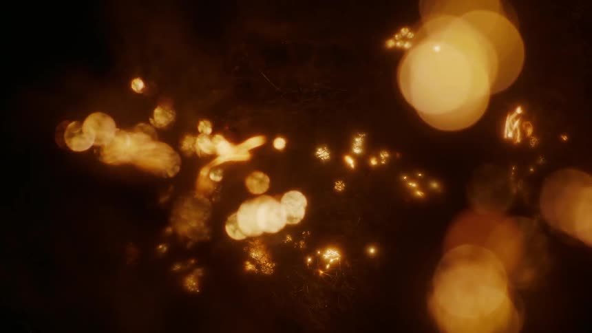 In a very dark setting small fibers are burned and smoldering