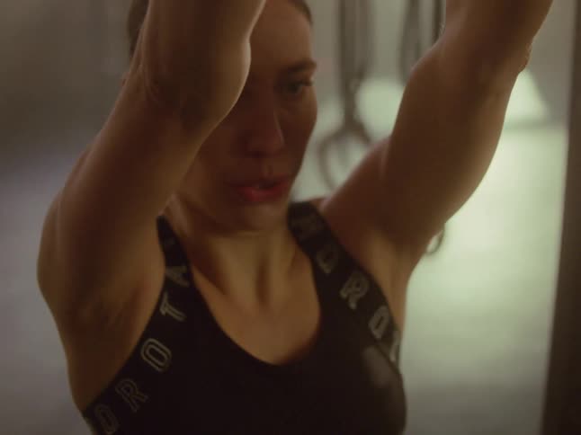 Woman breathing in a coordinated manner and lifting weights with dumbbells