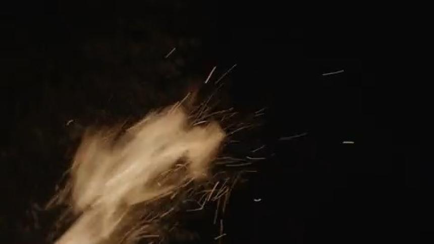 A view of a fire outdoors at night