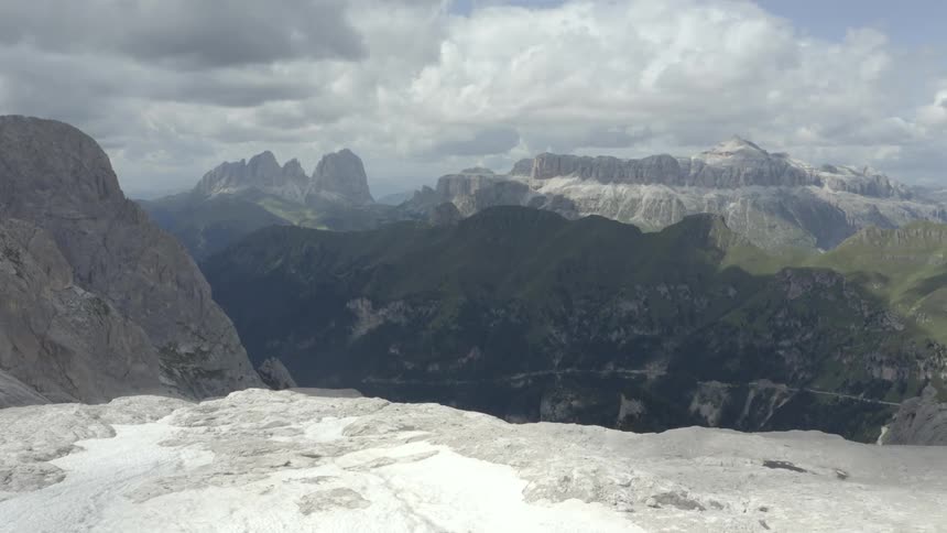 Natural panorama of rocky mountains with cliffs and slopes on a sunny day with clouds