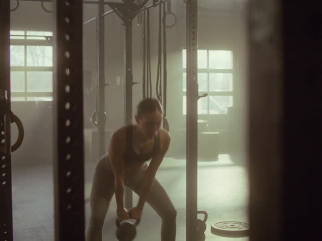 Woman doing kettle bell swings at a gym