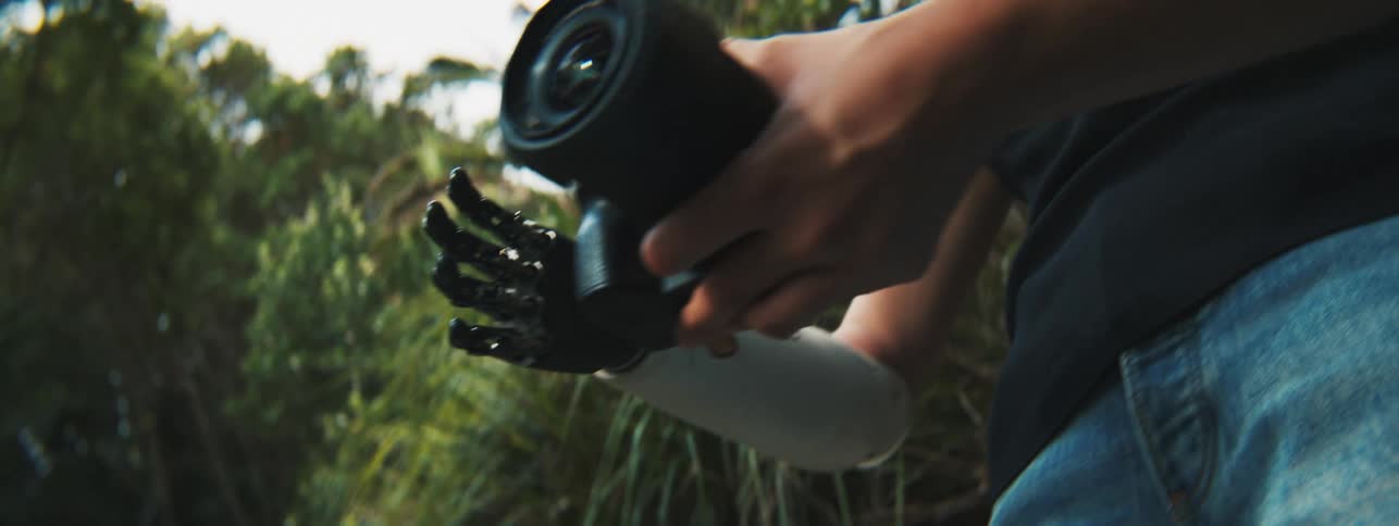 Female photographer holding a professional camera with one of her hands robotic