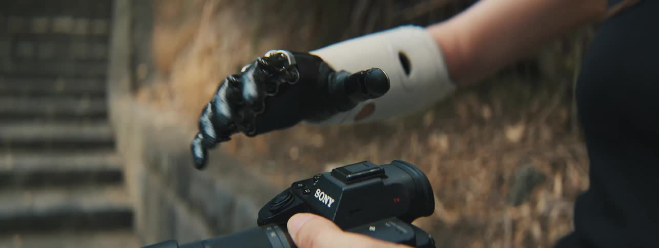 Close in the hands of a woman one of which is robotic
