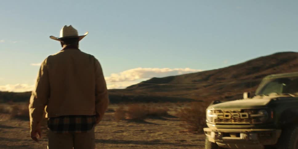 A man walks past his truck in the desert
