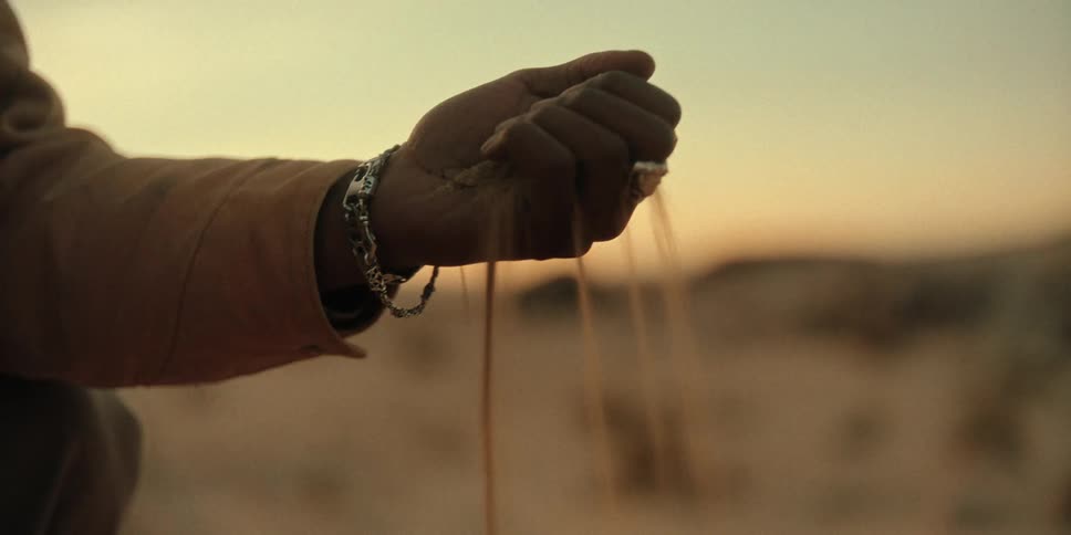Man opening his hand slowly and sand falling