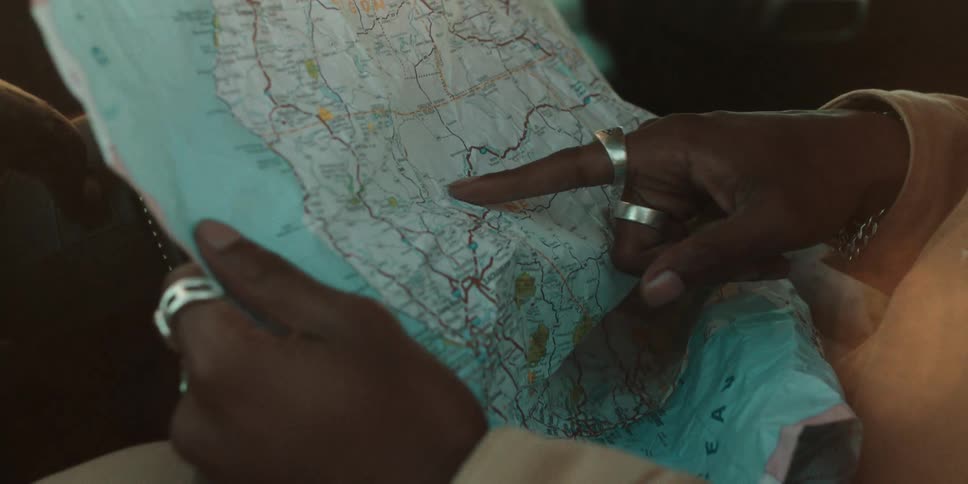 Hands of a person pointing with their finger and locating a location on a map