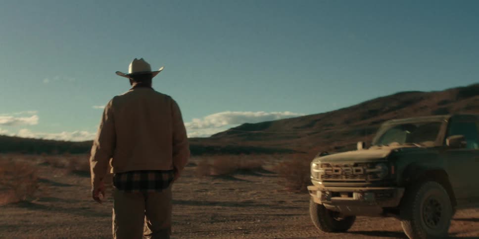 A man walks over to his truck in the desert