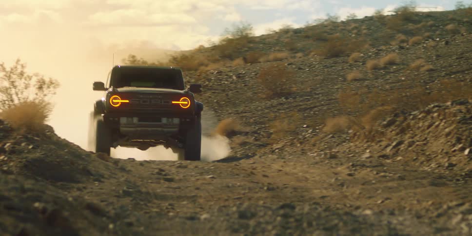 Lifted jeep with shock suspension and orange headlights off roading on rugged terrain