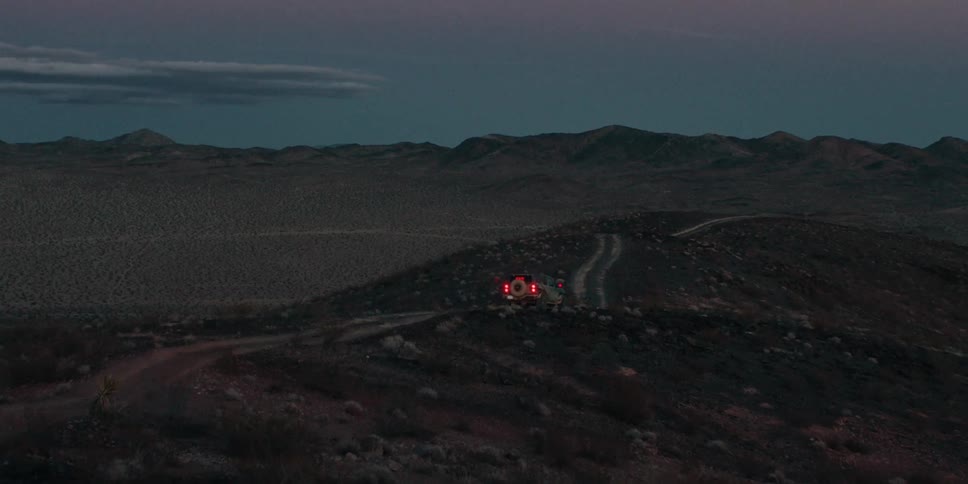 A truck is driving off road through the desert