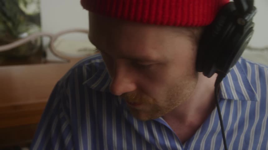 A musician puts on headphones and listens