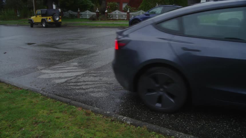 The car pulls away from the curb