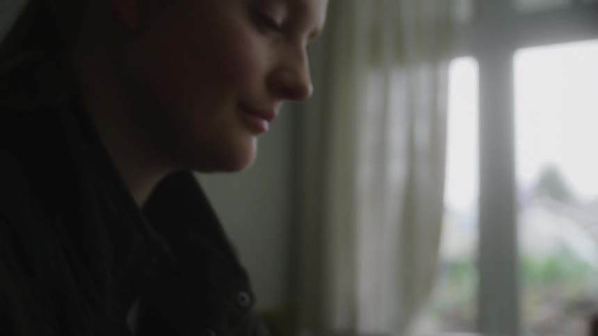 A young woman swipes on her smartphone