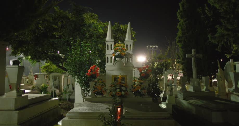 Cemetery with white tombstones at night
