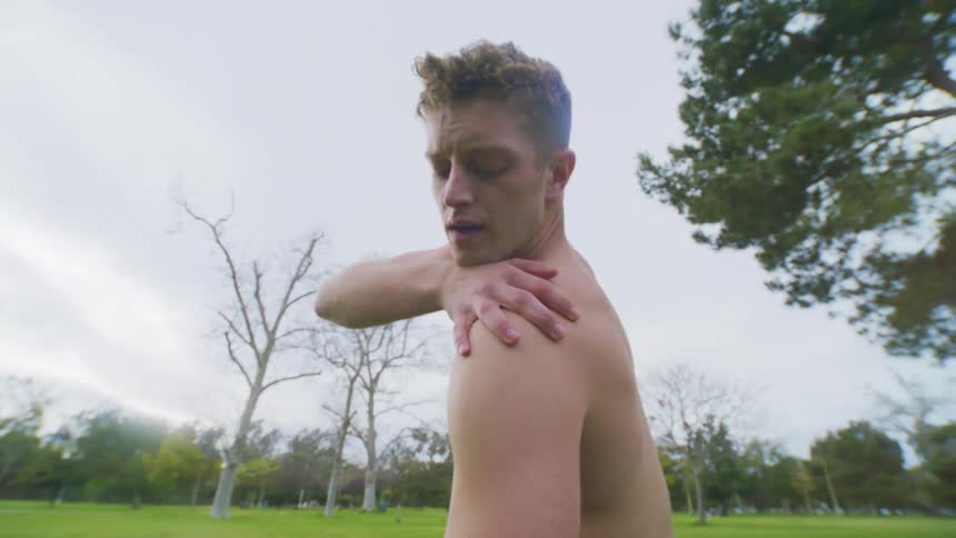 A man stretches in the grass