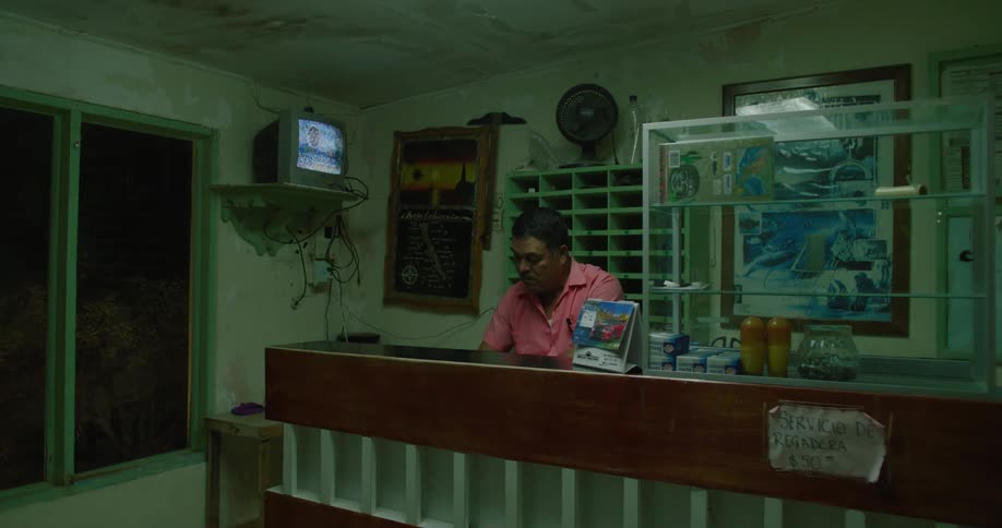 Man sitting inside a store at night