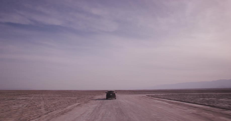 A car is driving in the desert