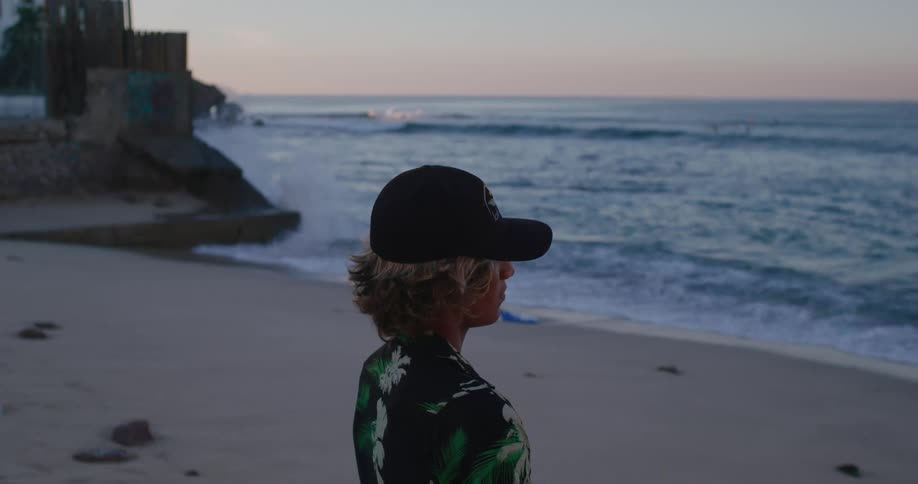 Side portrait of a young teenager on the beach sand one morning
