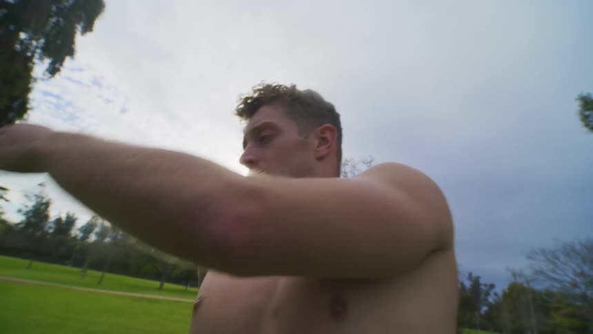 Man is dancing shirtless in an empty grassland location