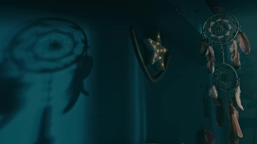 A dreamcatcher hangs above the bed
