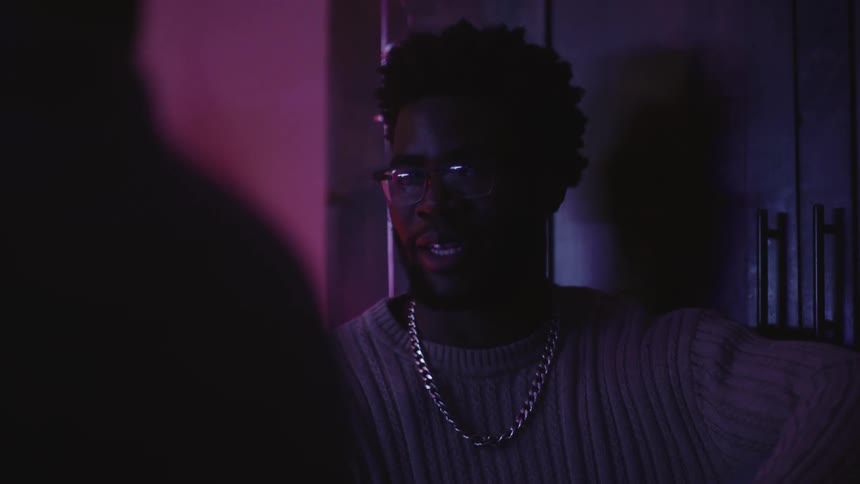 Portrait of a man in a lighting environment with purple light talking