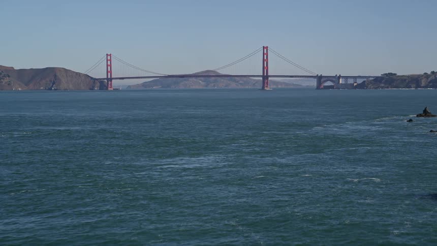 Scenery of the golden gate bridge on a blue sky day with calm sea