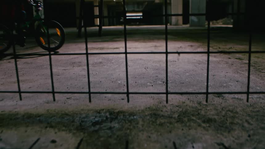 A bicyclist rides through an empty warehouse