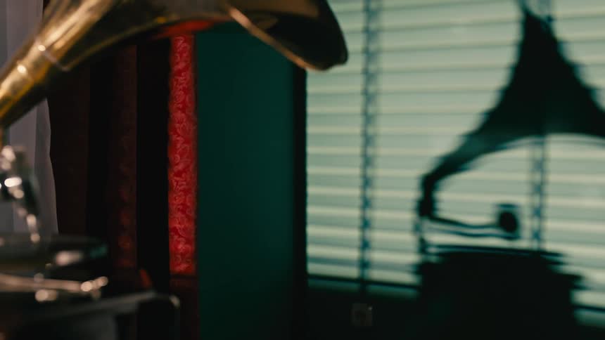 Person casts silhouette while starting a record on the gramophone