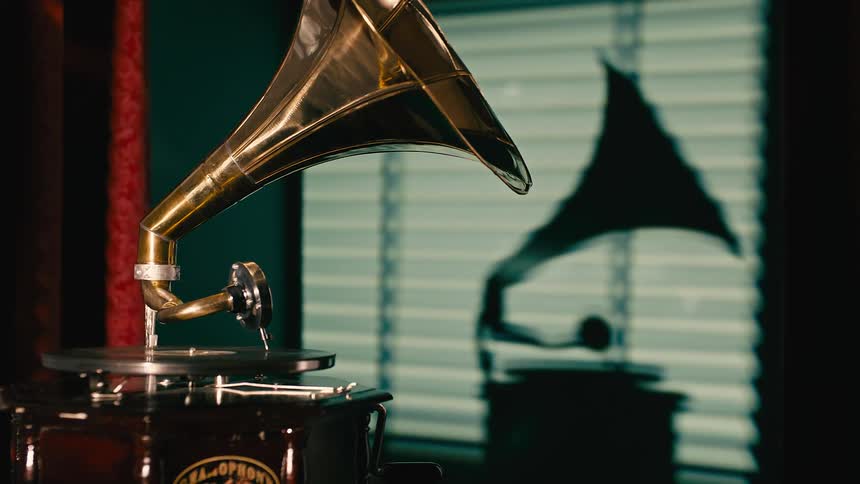 A person plays a record on a phonograph