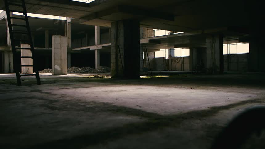 A child riding a bicycle around in an abandoned building