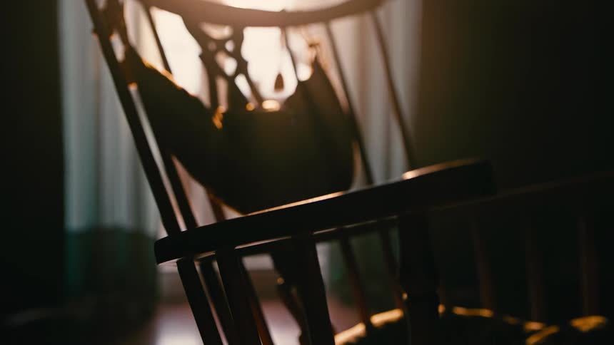 Rustic wooden chair inside a room with the window reflecting sunlight