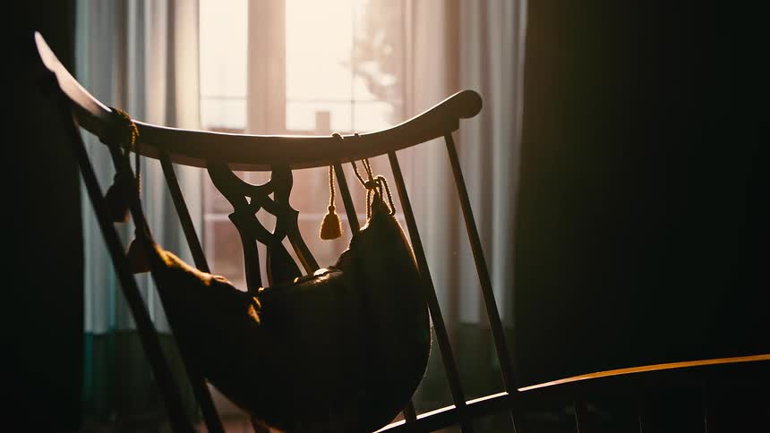 The rocking chair is empty in the small room